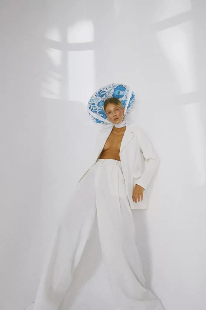 EolantaMarina in white outfit, blue headpiece, bare stomach, confident stance.