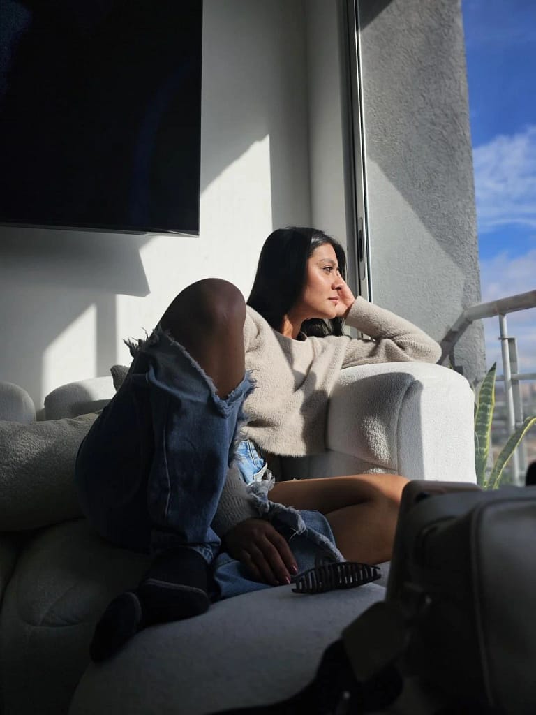 ThaliaAres sitting on the couch looking out